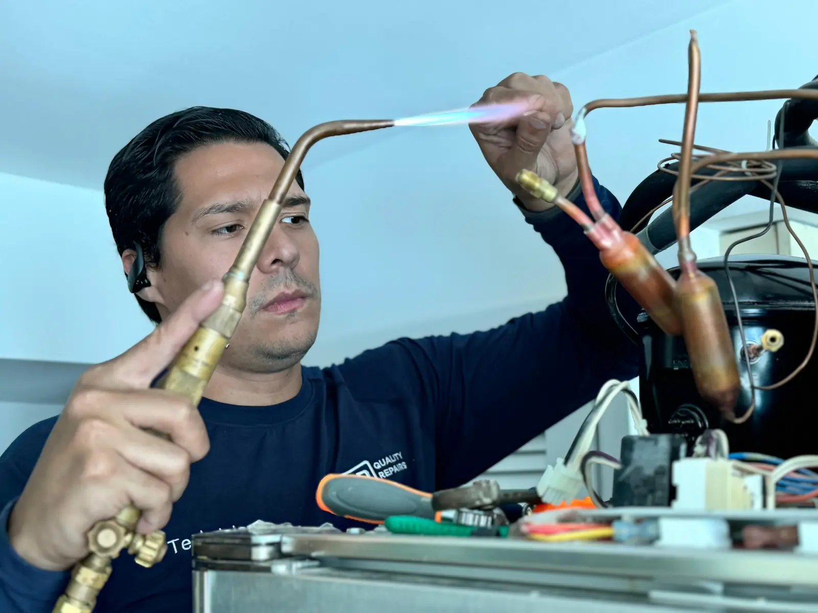 Quality Repairs technician brazing a refrigerator sealed-system line